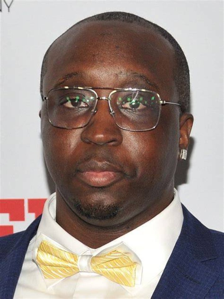 Isaiah Stokes can be seen wearing a grey suit as he is posing for the picture.